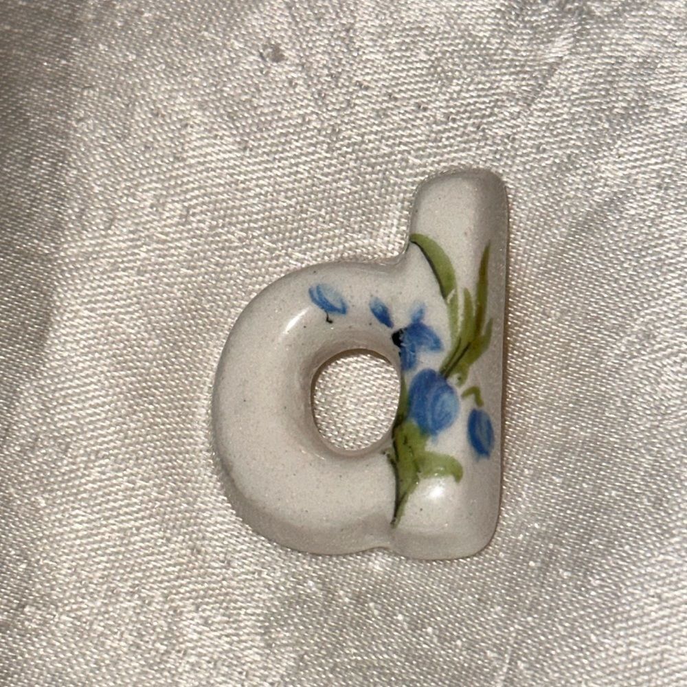 Vintage white ceramic blue floral painted D woman’s lapel pin